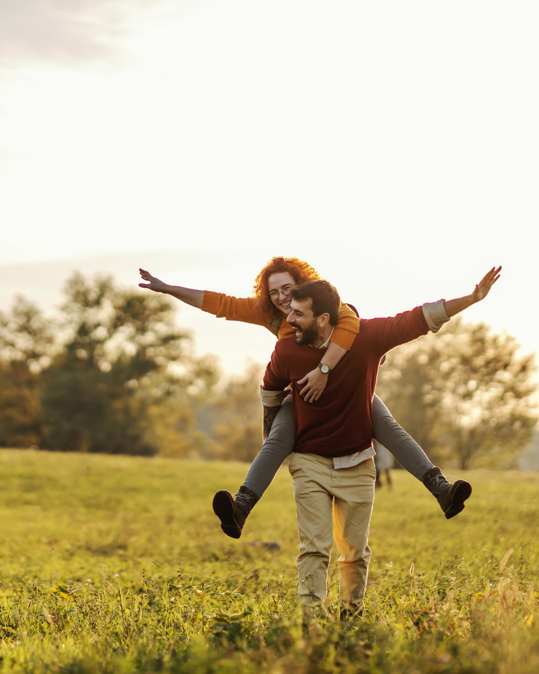 A joyful couple enjoying a playful moment outdoors, symbolizing emotional connection and growth through relationship therapy.