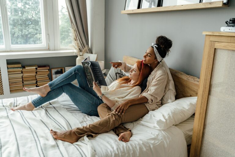 Two people relaxing together on a bed while reading, reflecting closeness, comfort, and the exploration of attachment patterns in relationships, at The Mindful Place in Ontario.
